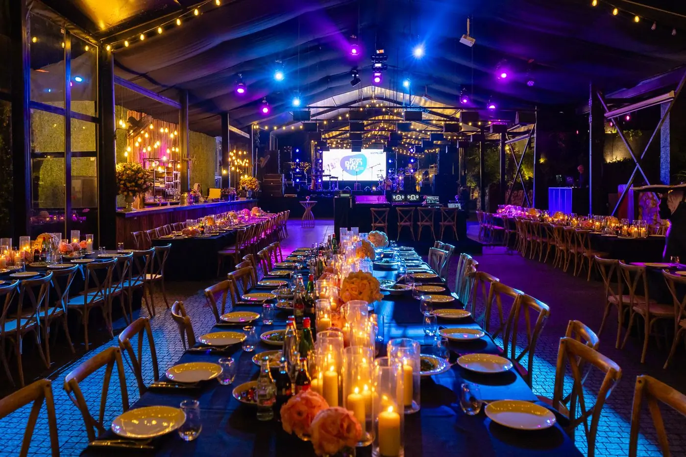 A candlelit banquet room laid for a gala dinner