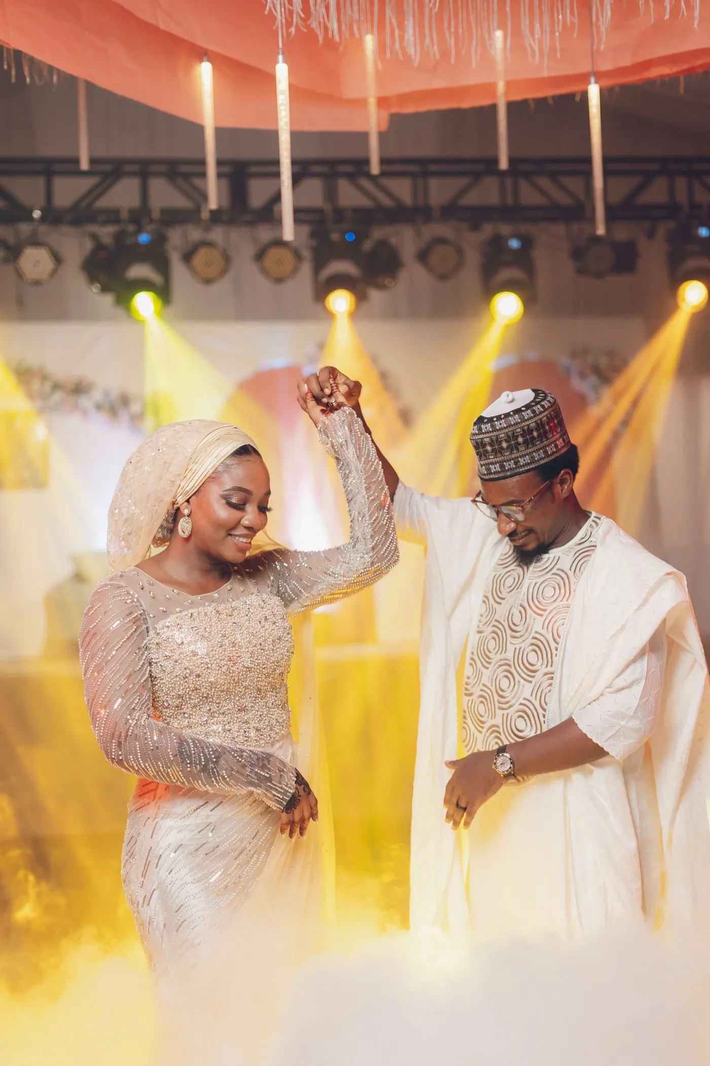 A couple dancing at a wedding reception in traditional dress