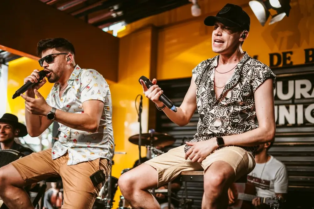 Two vocalists performing together on a small stage