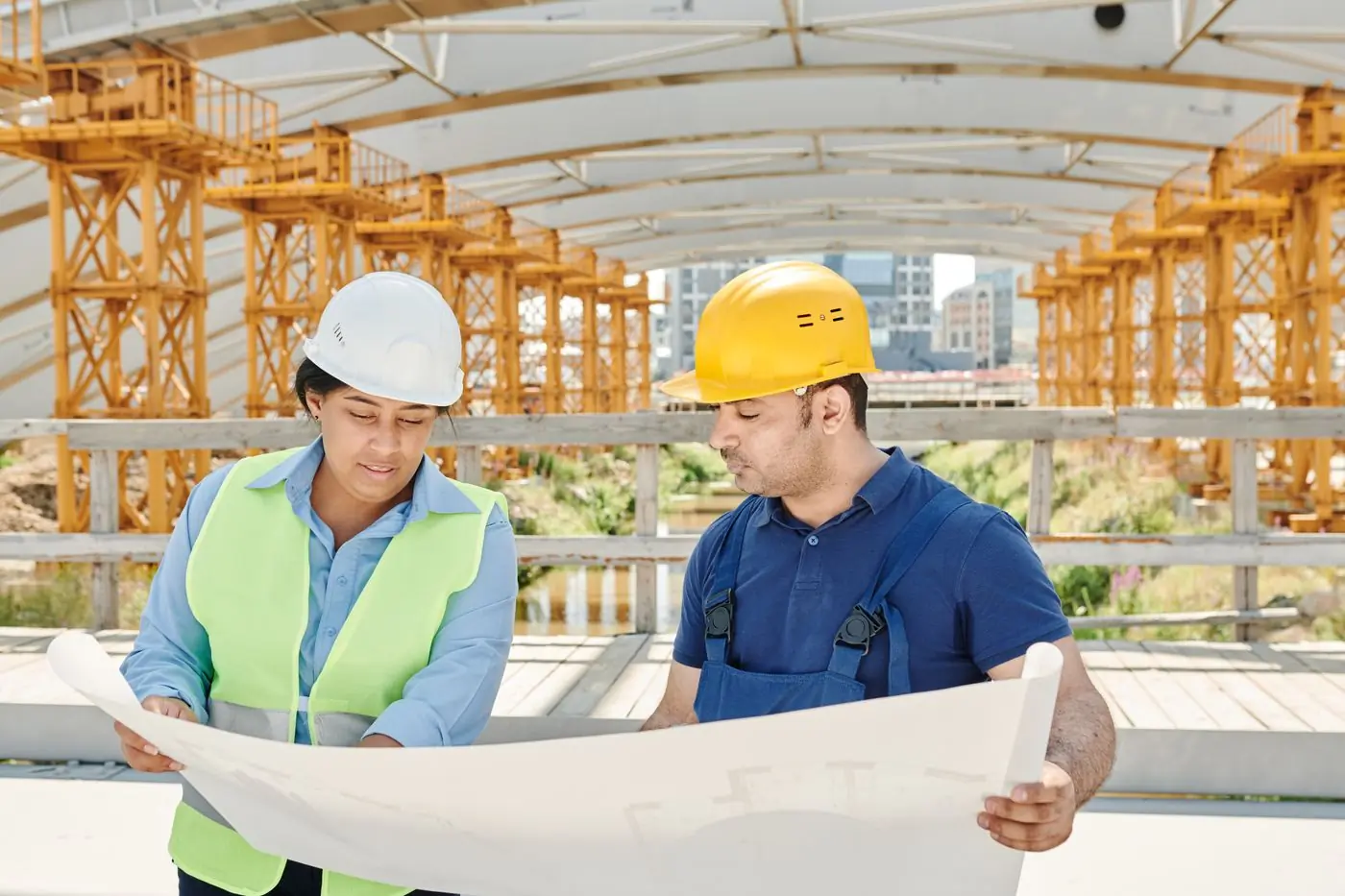 Two engineers checking a drawing against the frame on site