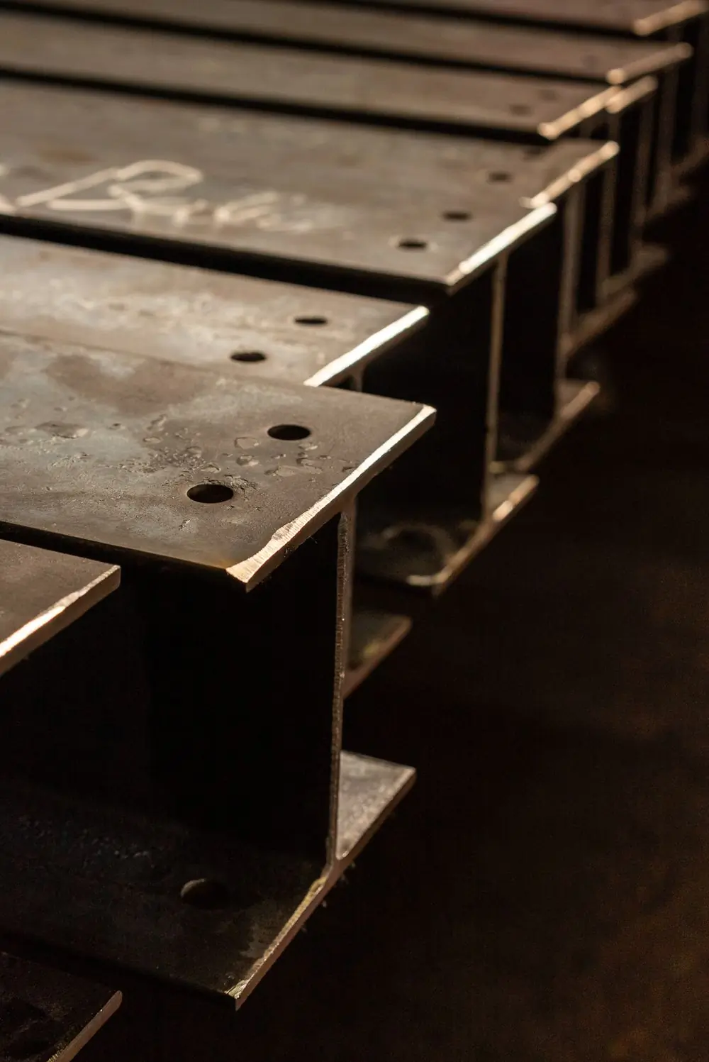 Stacked steel I-beams in low light
