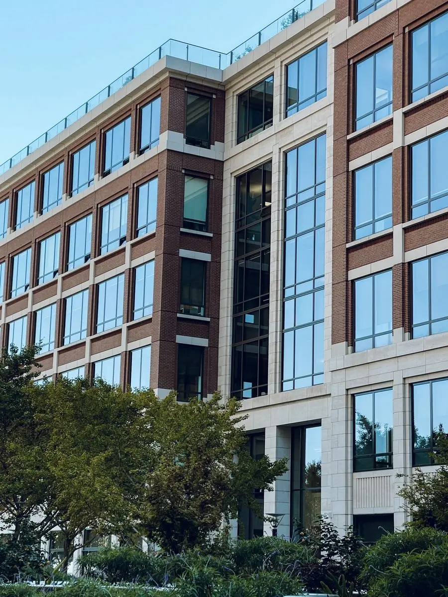 A modern clinical block behind mature trees