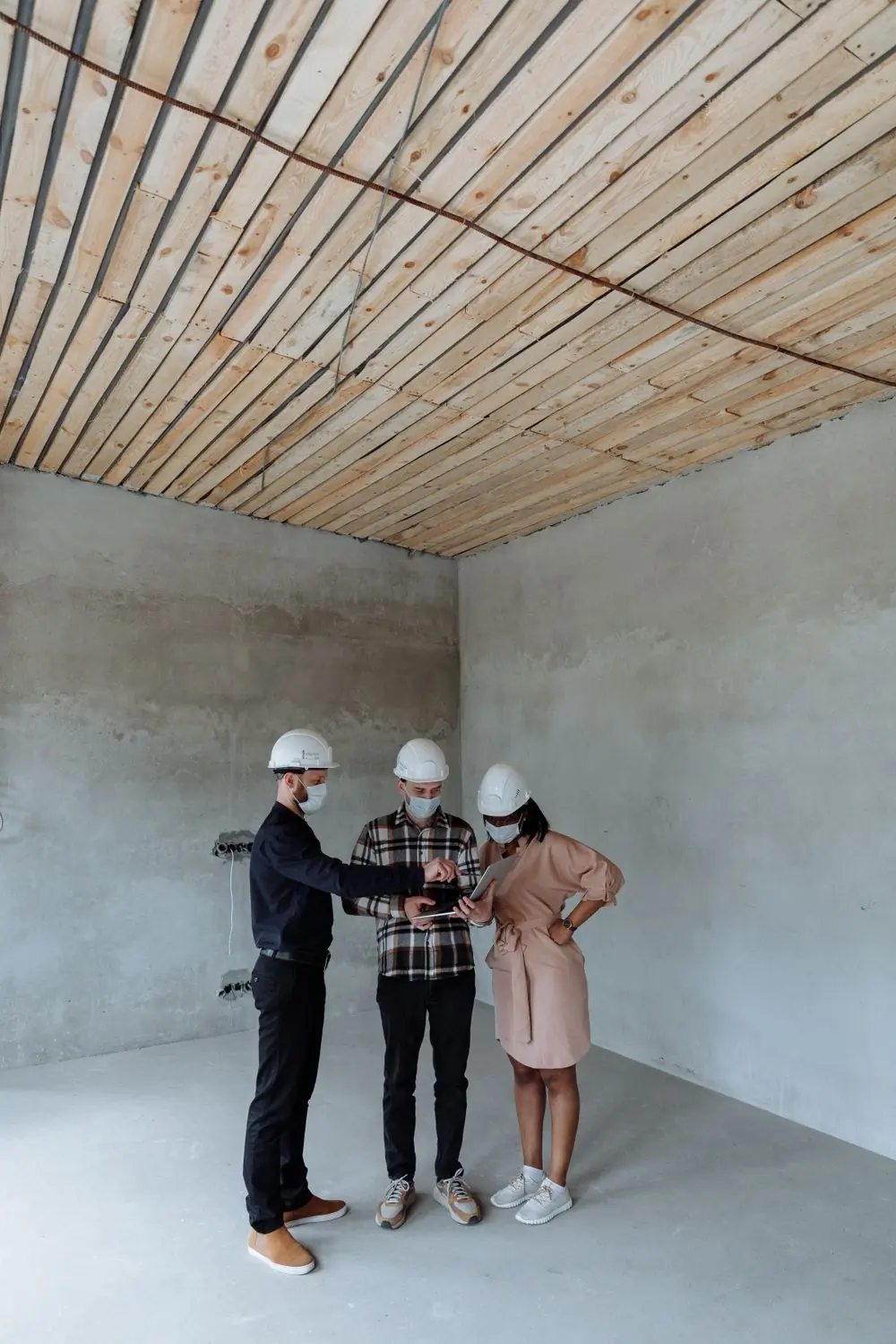 A project team reviewing plans in an unfinished room