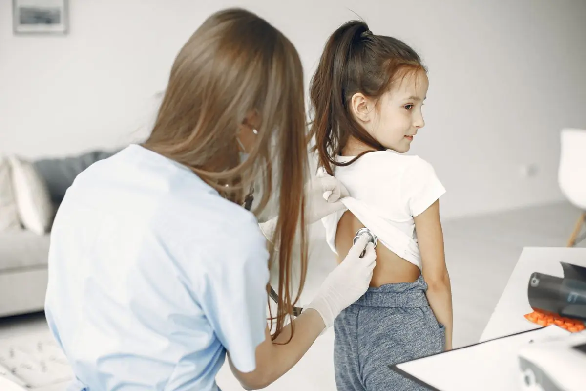 A doctor examining a young child with a stethoscope