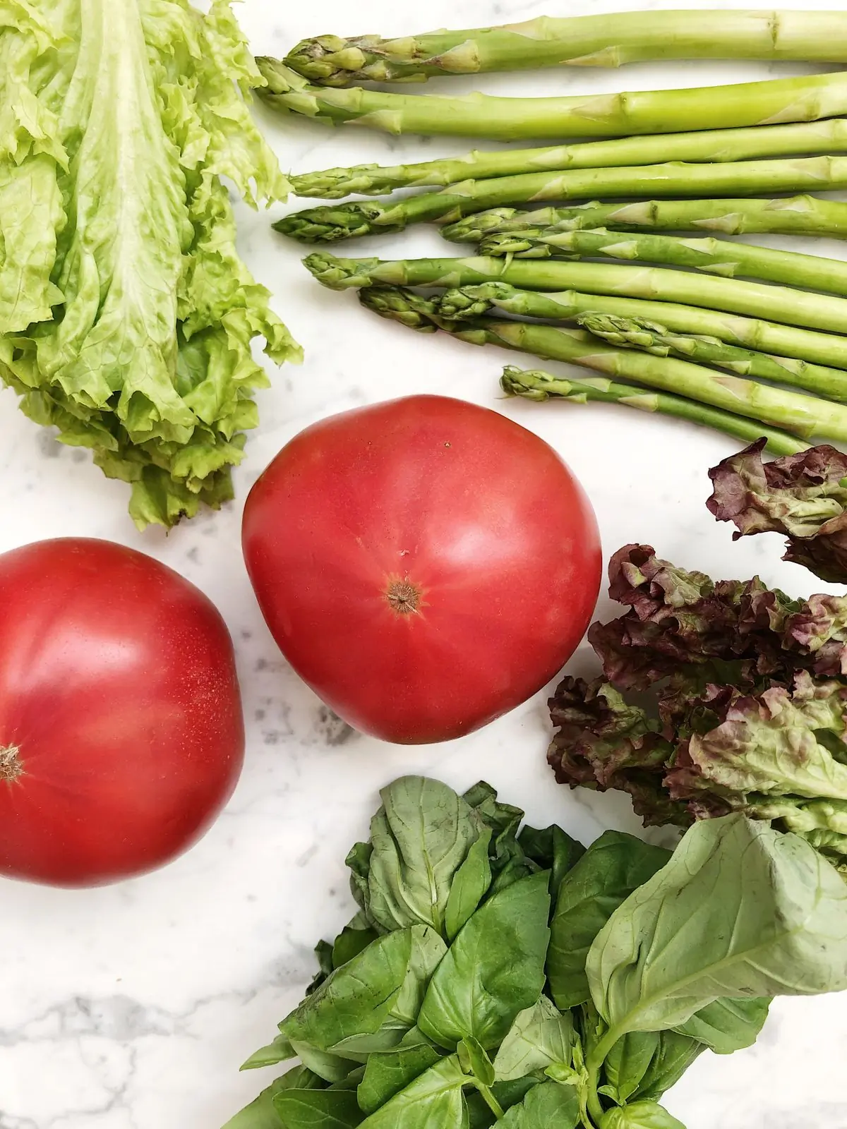 Fresh vegetables arranged on a marble surface