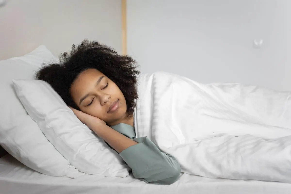 A woman sleeping peacefully in a bright bedroom