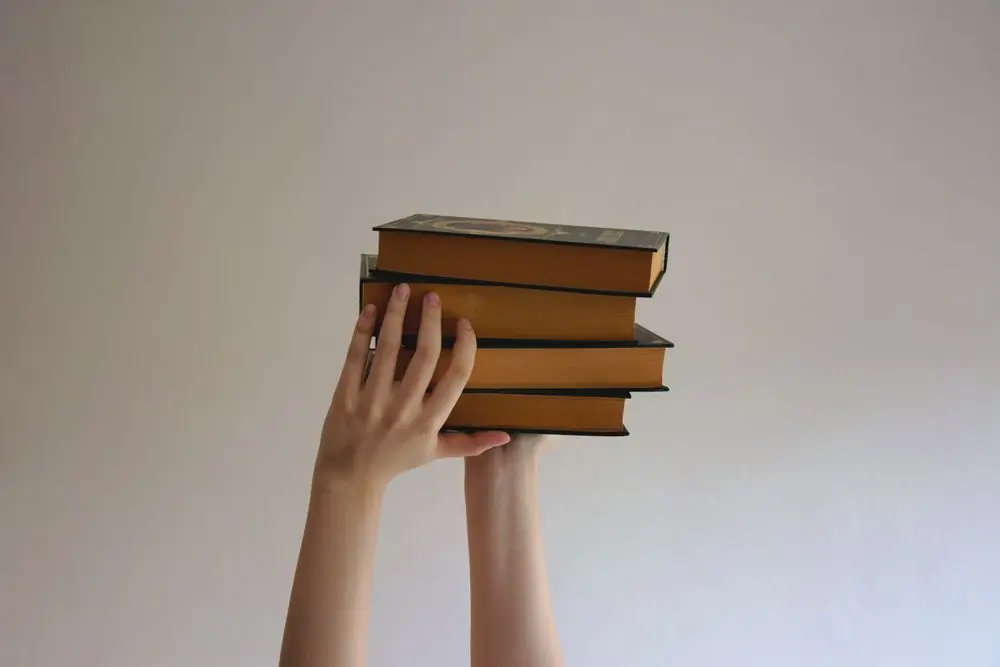 A hand holding a stack of bound law reports