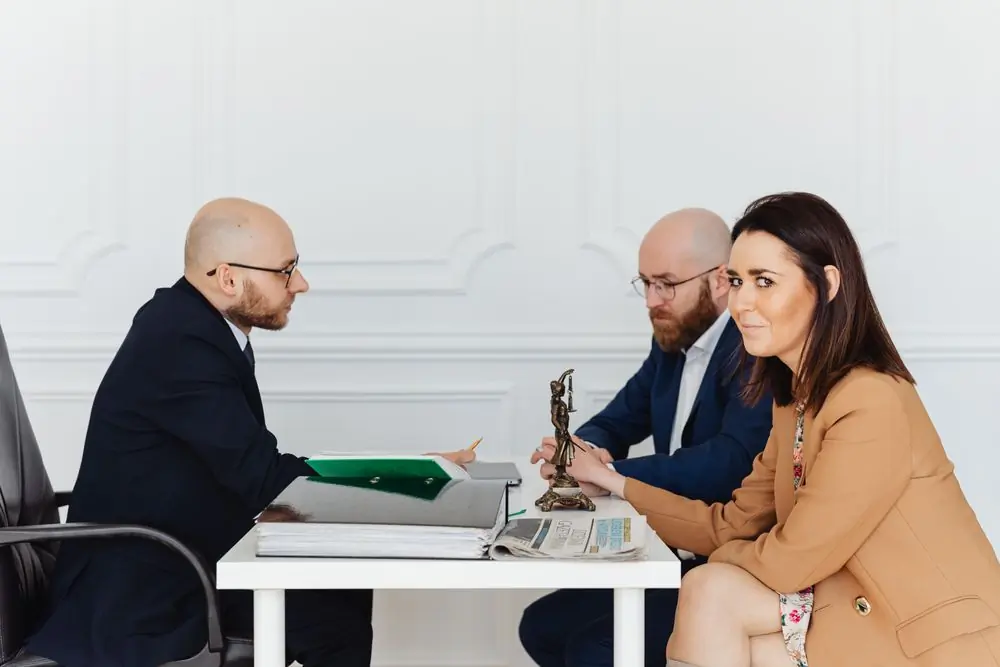 A couple meeting their lawyer across a desk