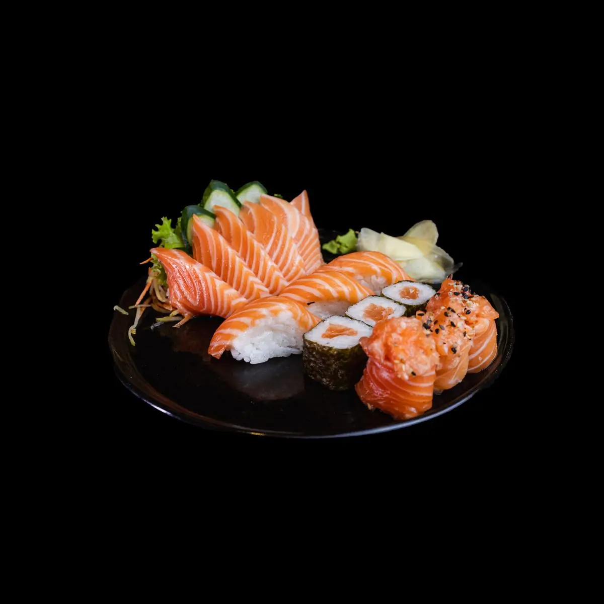 A sushi platter of salmon nigiri and rolls on a black plate