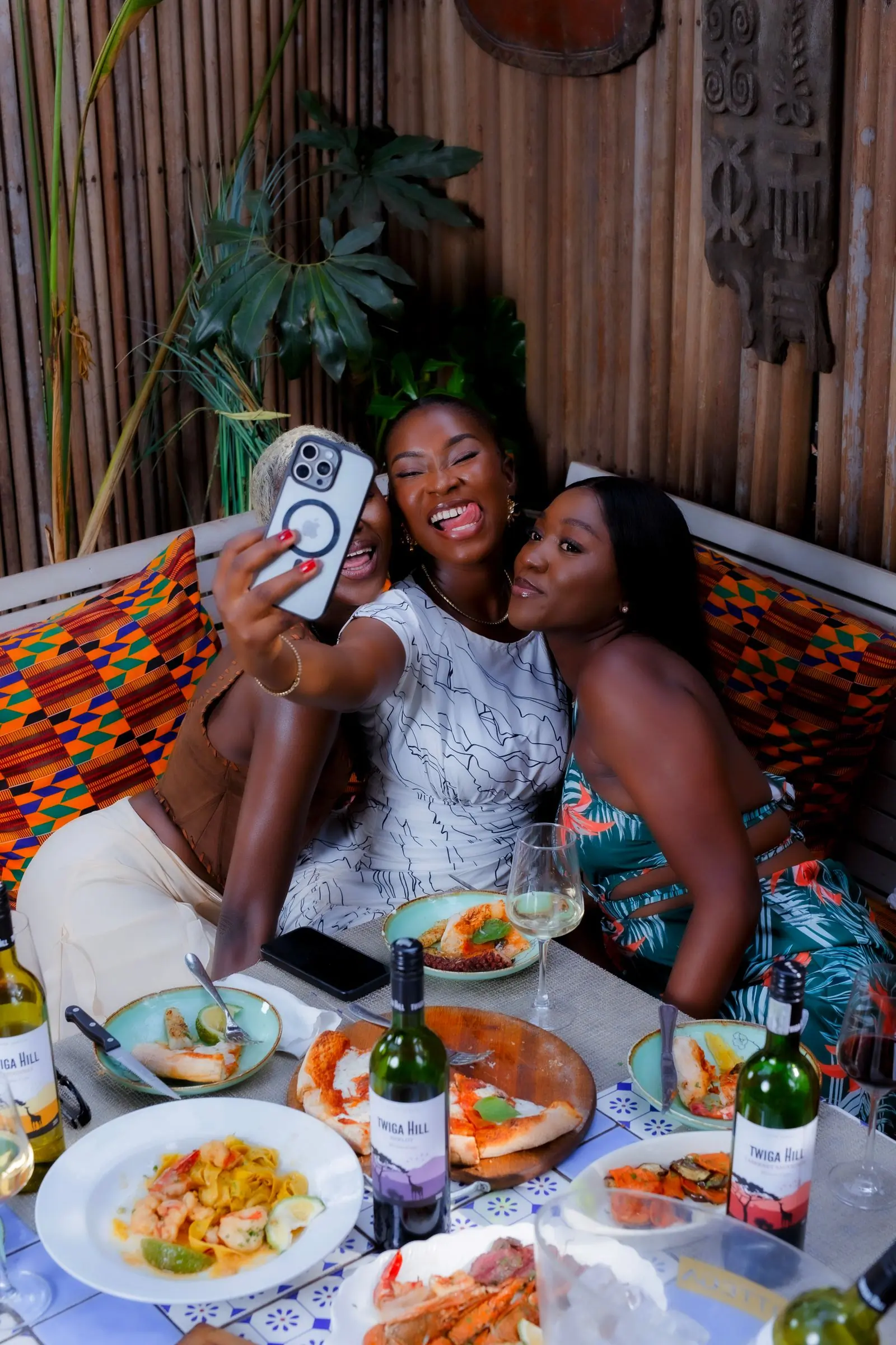 Friends laughing over a shared plate at a table in Accra
