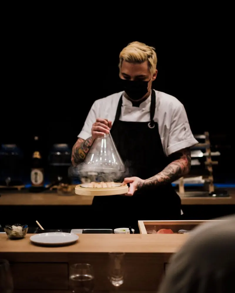 Ryo Tanaka lifting a cloche at the pass