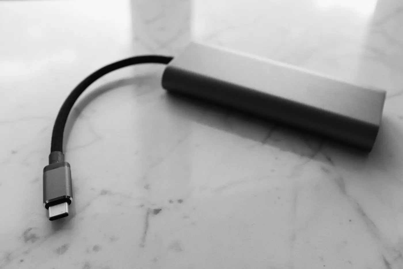 A charging pack and its cable on a pale marble surface