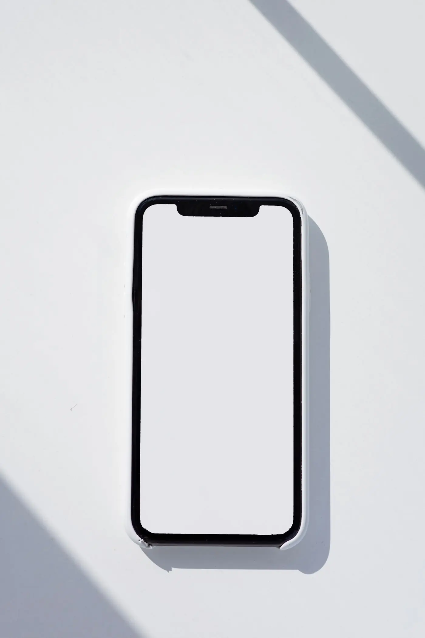 A smartphone lying on a bright white surface