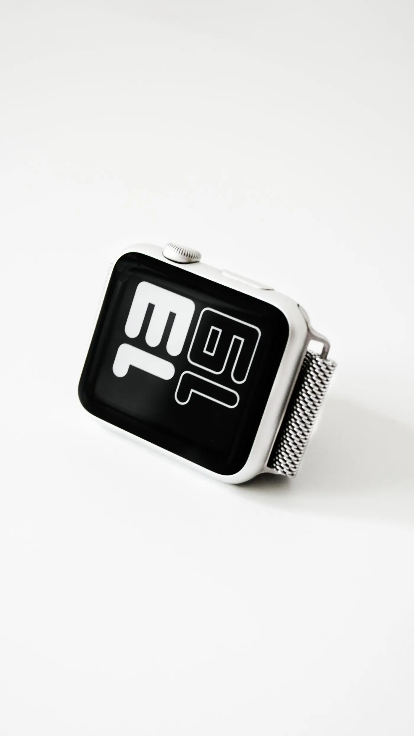 A silver smartwatch with a digital face, on white