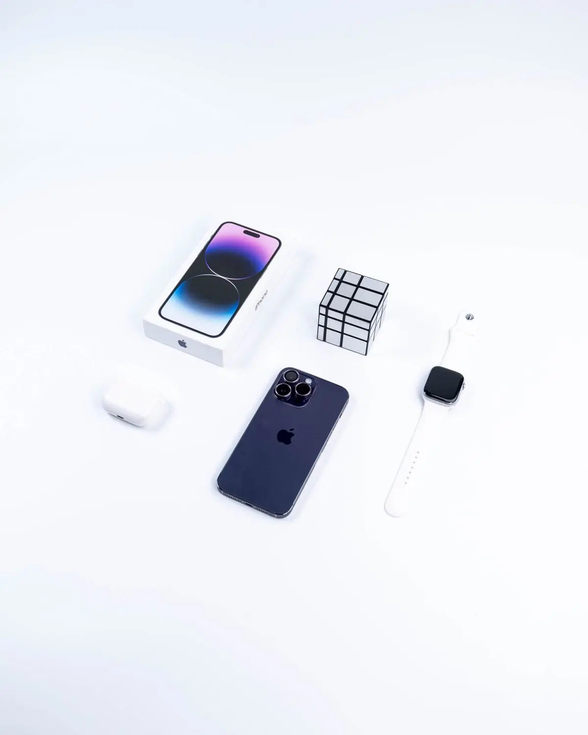 A new phone lying beside its open box, cable and papers on a white surface