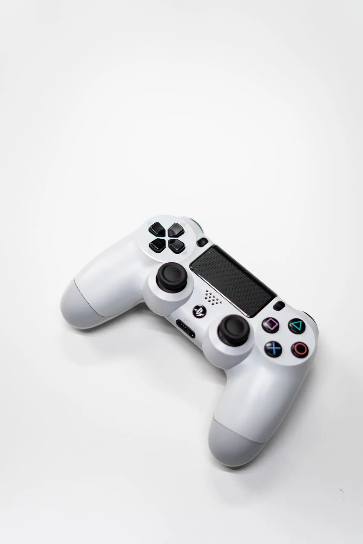 A white wireless game controller on a plain white ground
