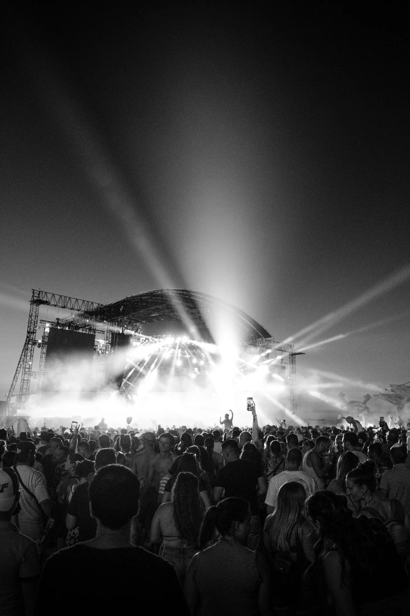 Light beams fanning out over a main stage and its crowd