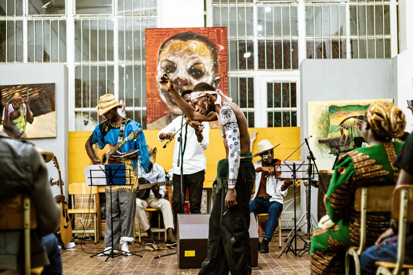 A masked performance with a live band in a daylit hall