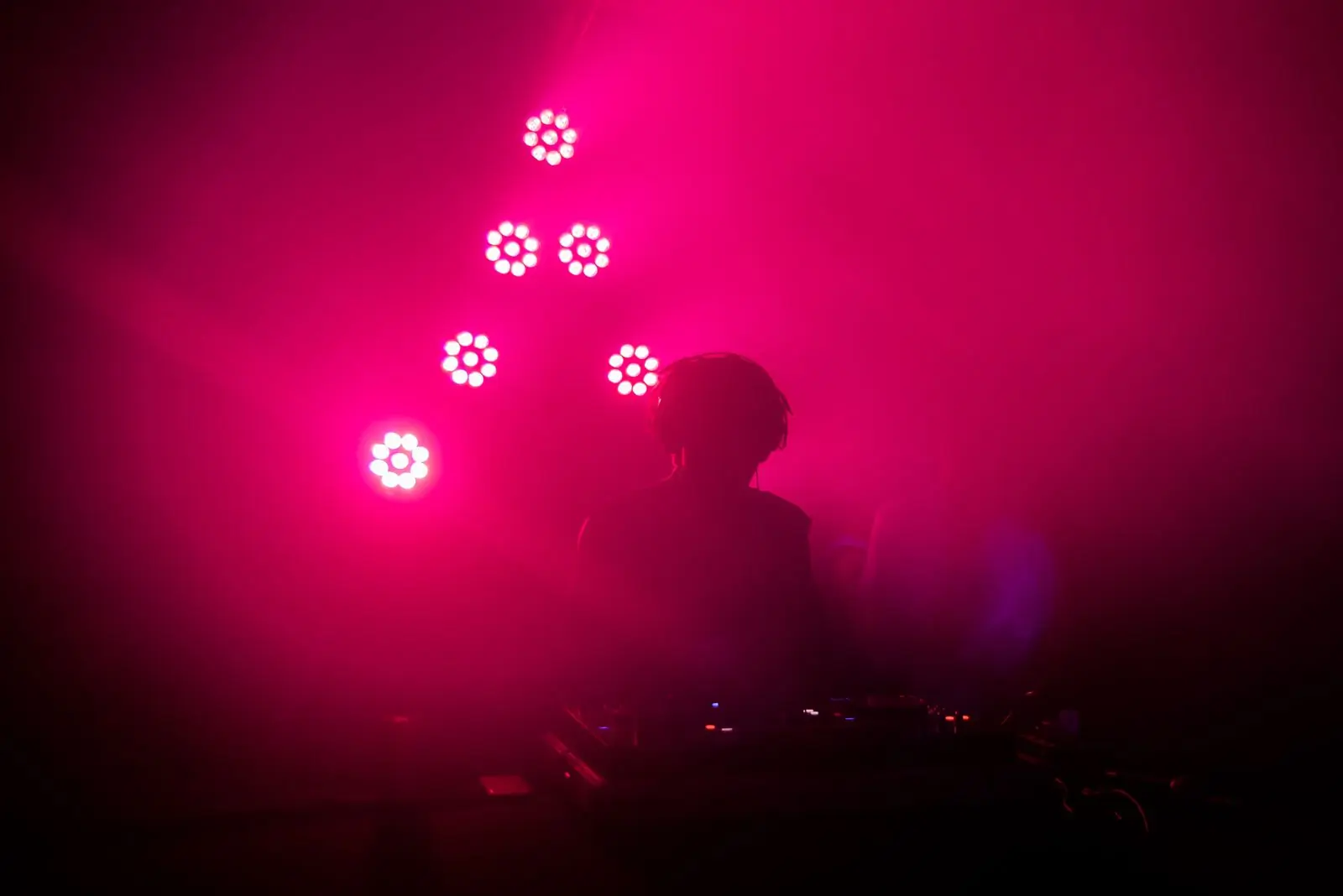 A selector silhouetted against a wall of magenta light