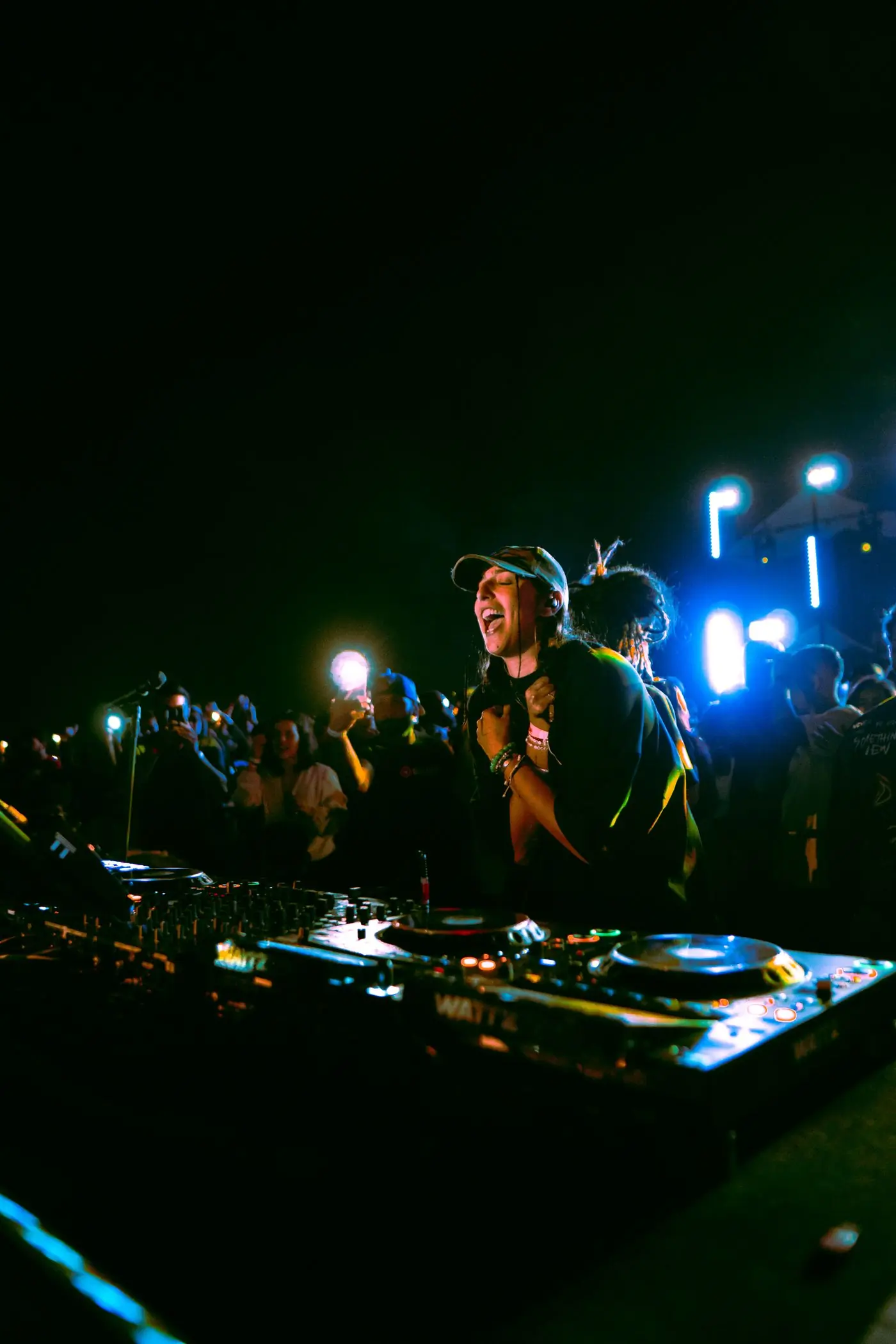 A selector playing to a crowd holding phones up at night