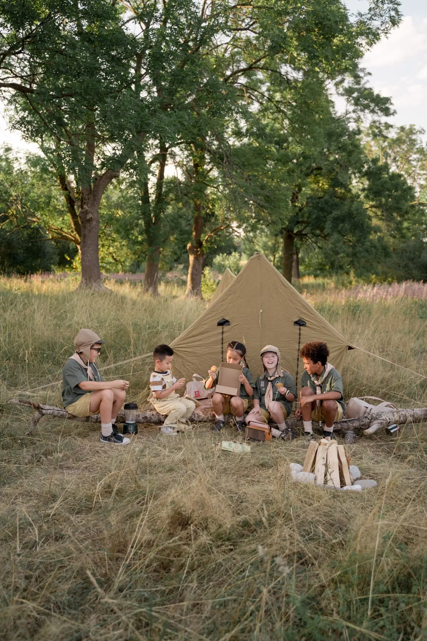 Campers sitting together outside their tent at the end of an afternoon session