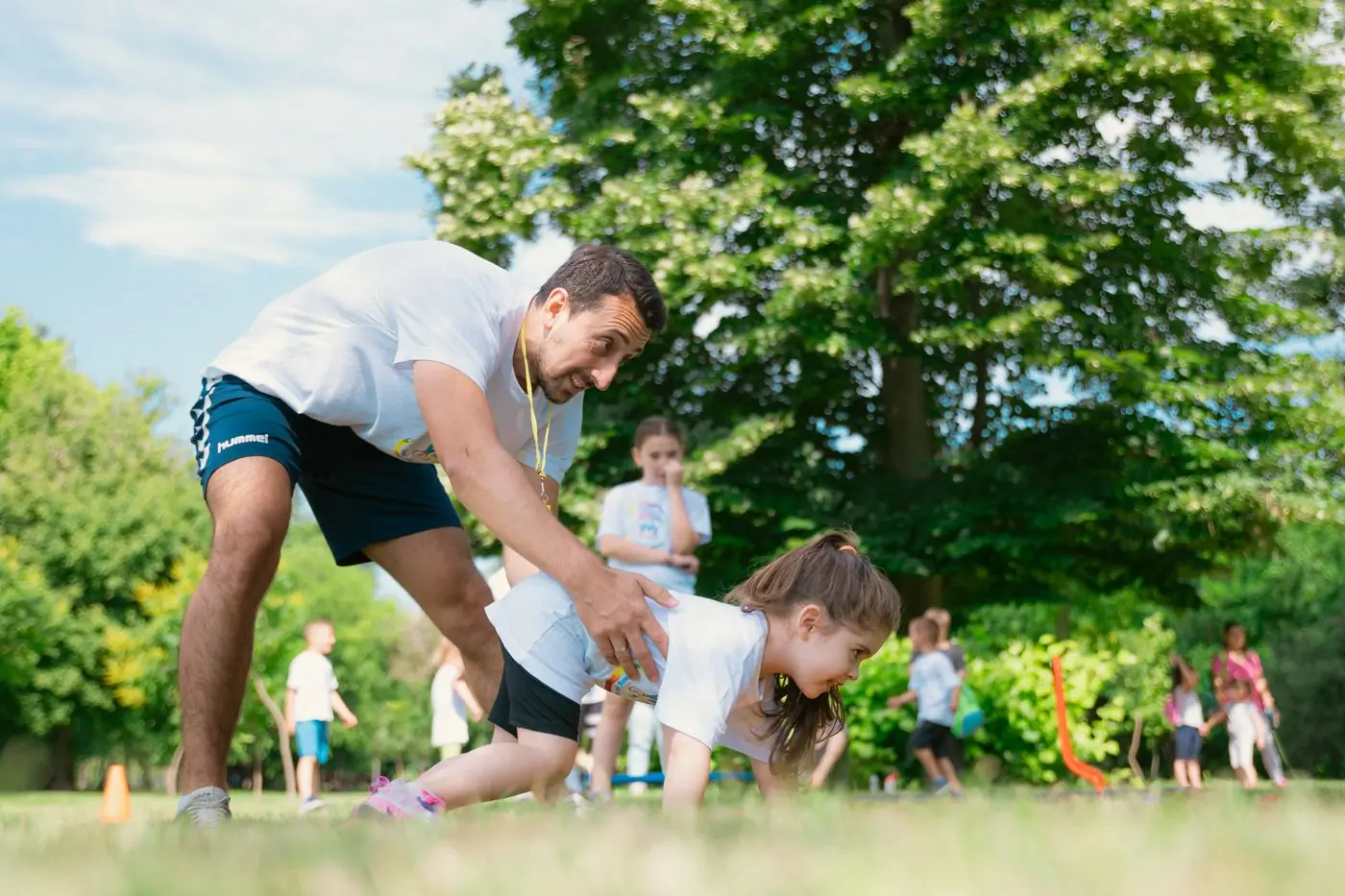 A coach working with a group of children on the grass
