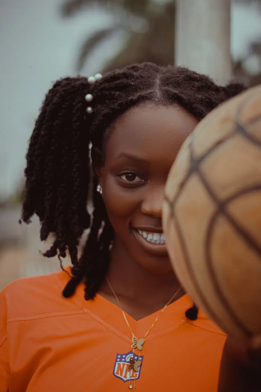 Adjoa Boakye, head of basketball, holding a ball at the court