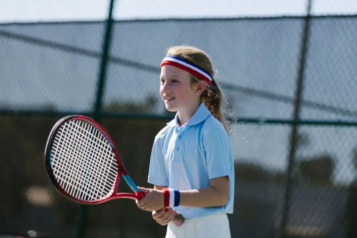 A camper waiting to receive at the camp tennis courts