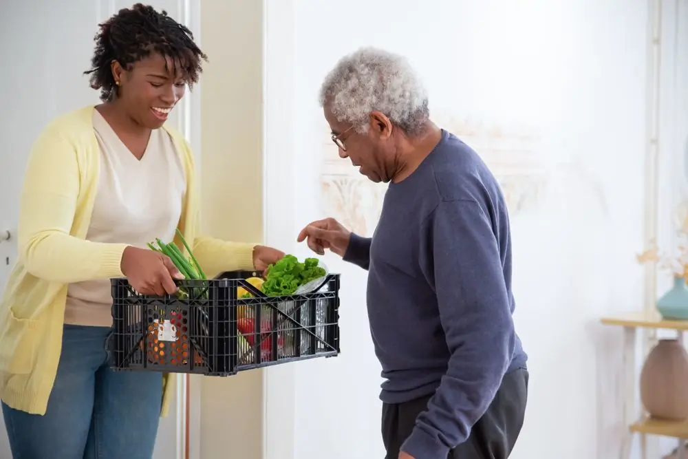 A carer arriving at a patient's home with the week's shopping