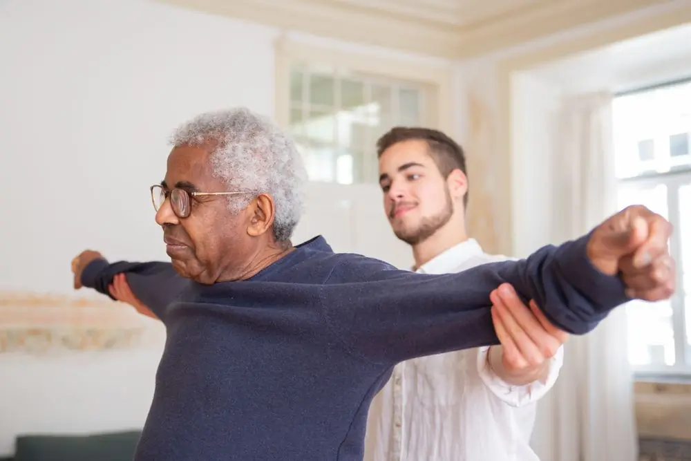A physiotherapist working through arm exercises with a patient