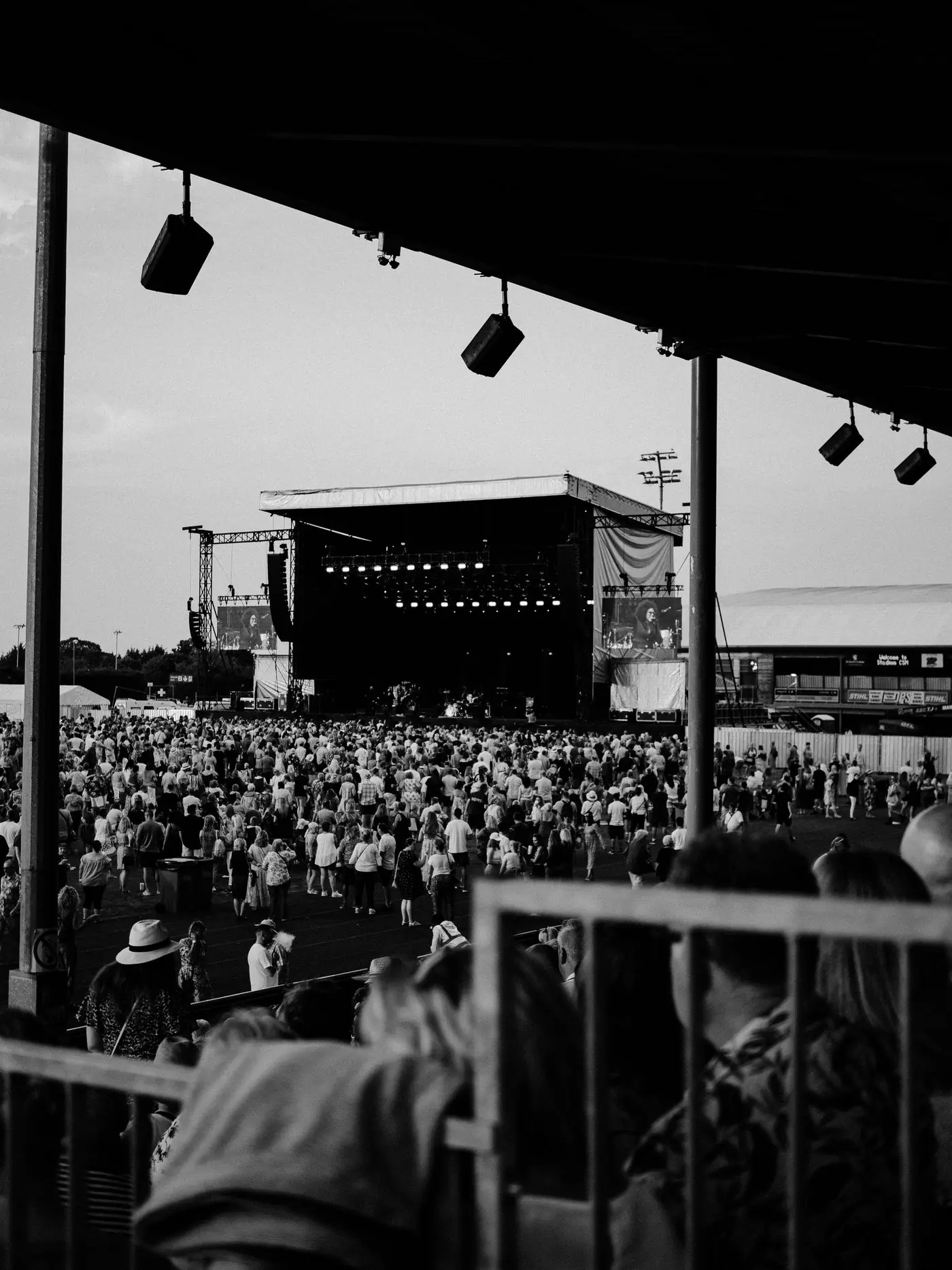 A festival field seen from the back with the stage in the distance
