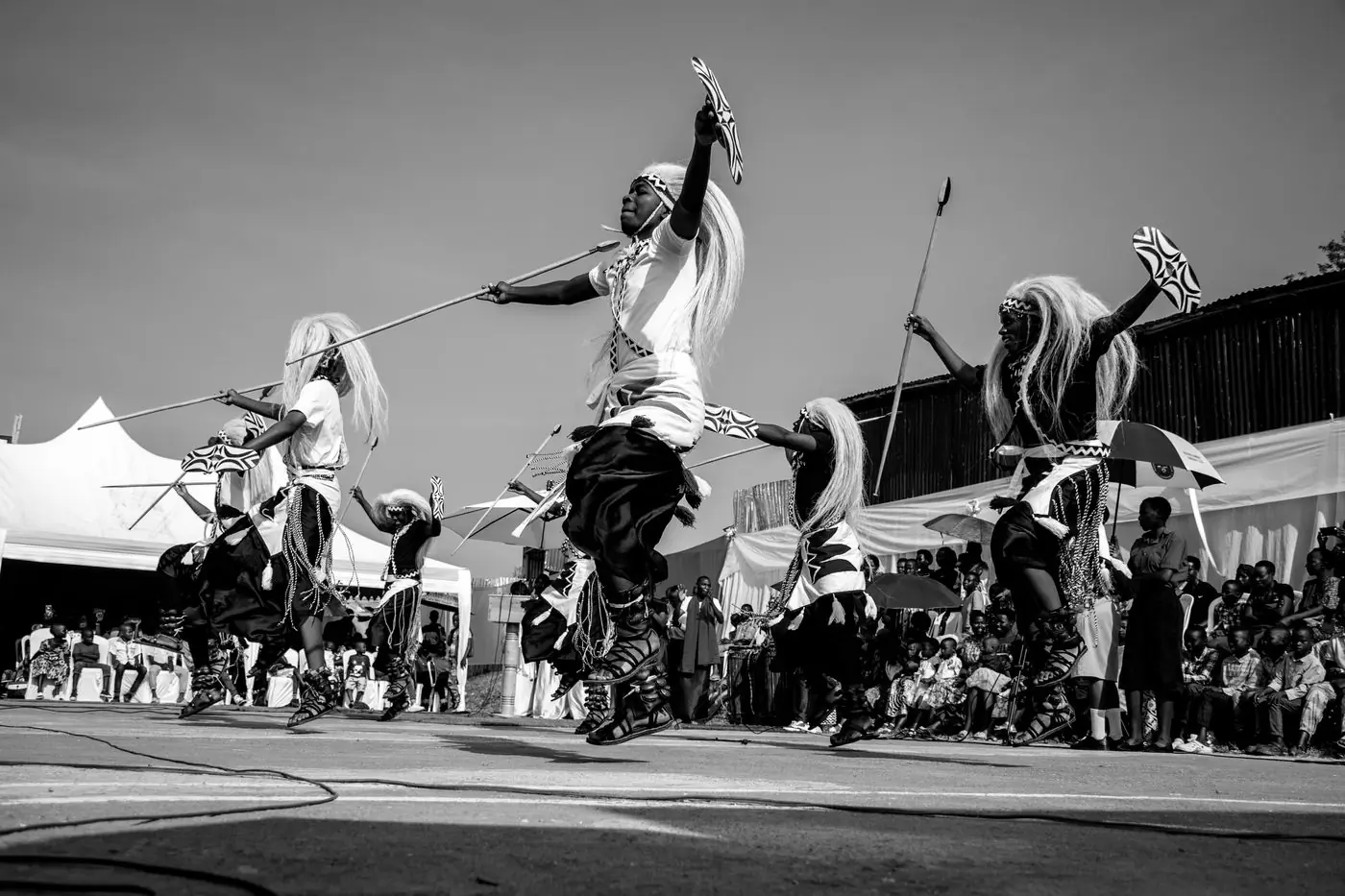 A dance troupe mid-leap at an outdoor cultural performance