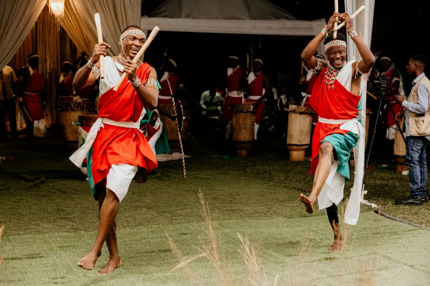 Dancers in traditional dress performing at night beside drummers