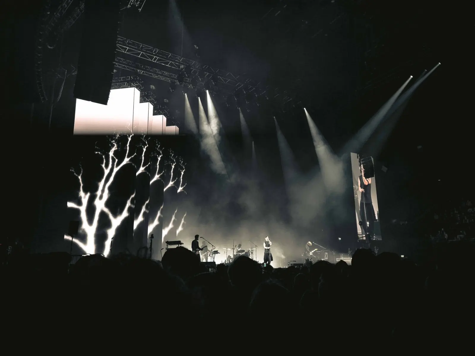 Light beams cutting through haze above a concert stage