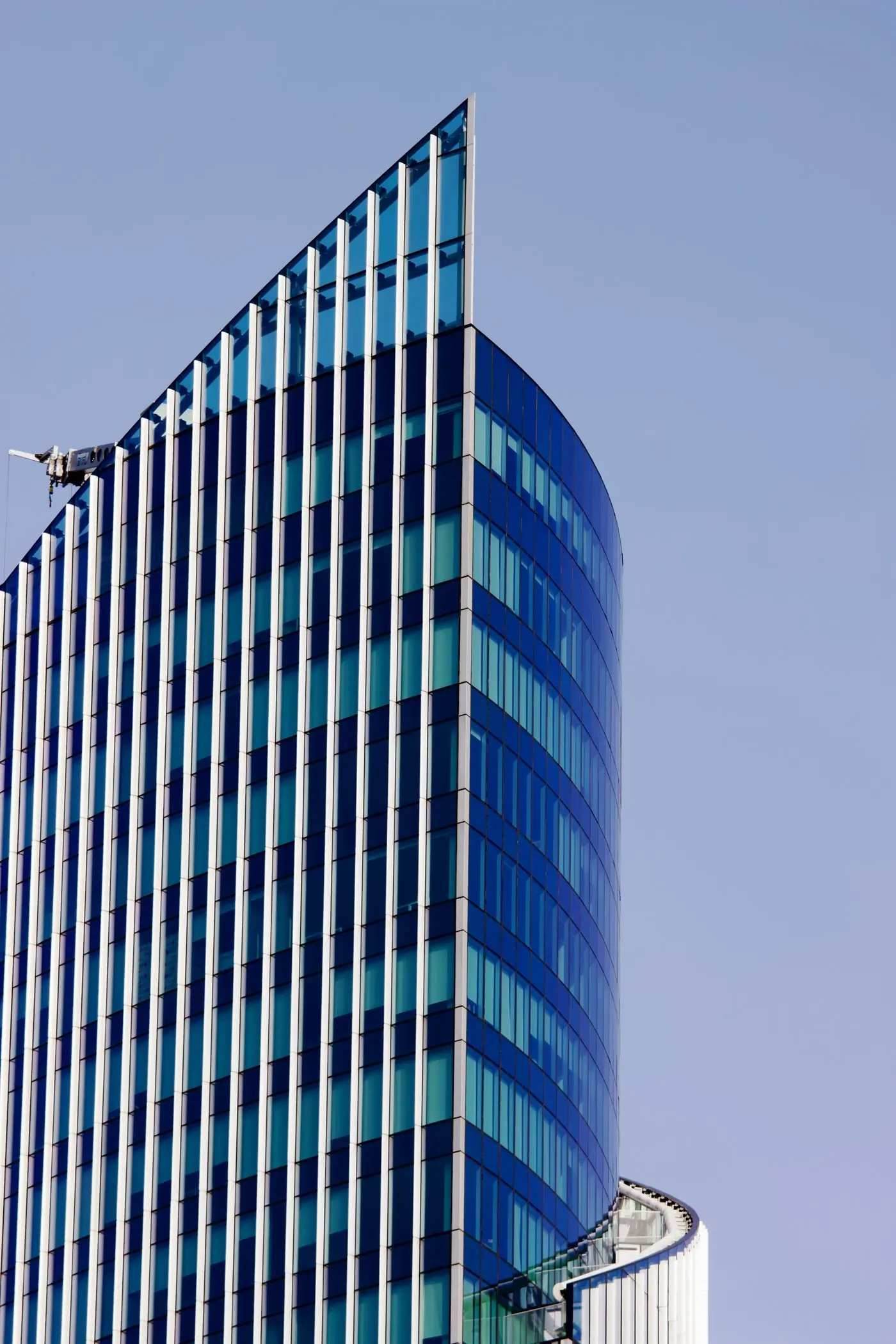The glazed Airport City Business Tower against a clear sky