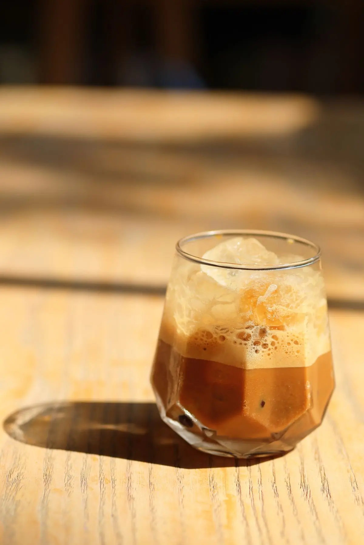 A glass of cold brew with its foam head, in late afternoon light