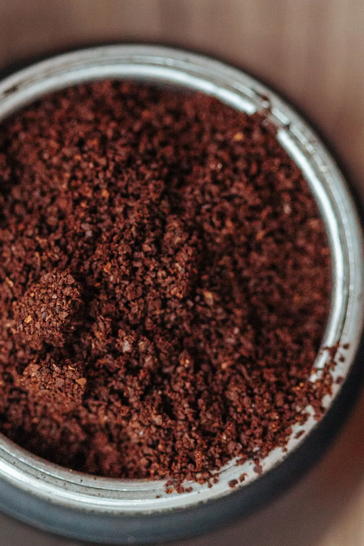 Freshly ground coffee filling a steel-rimmed canister