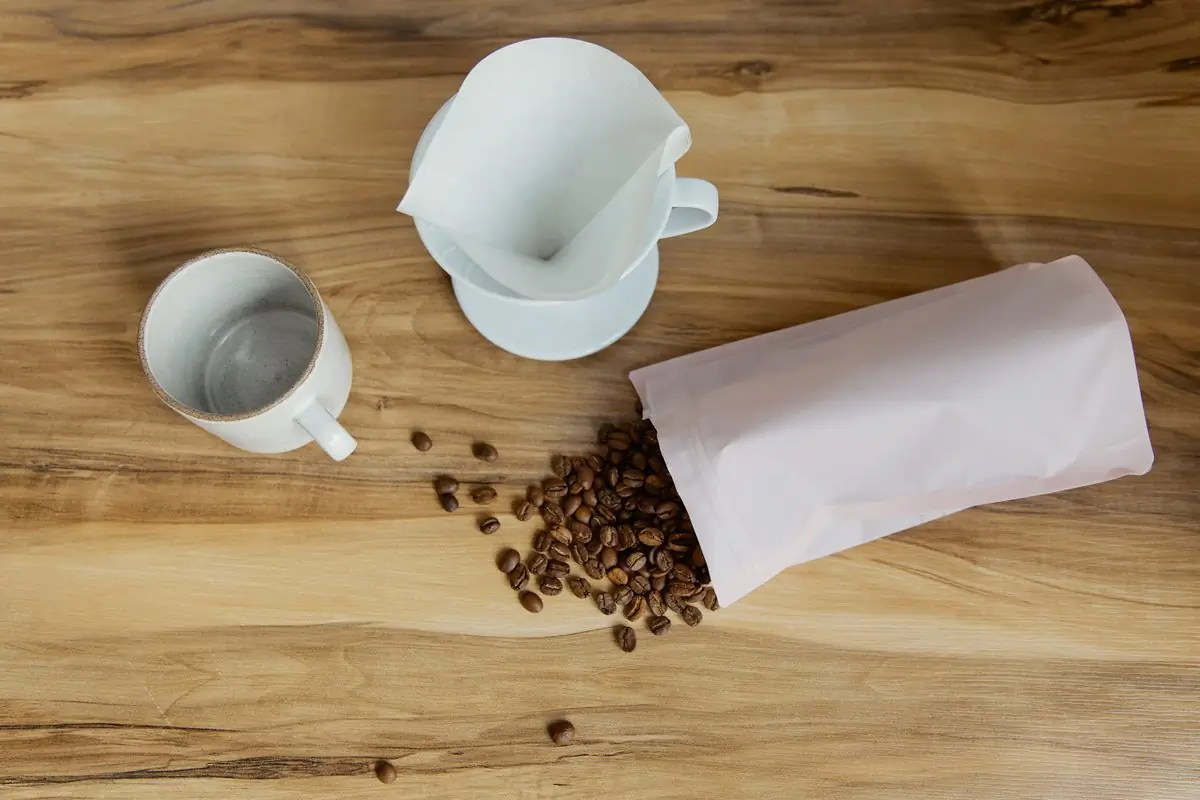 The Volta bag open on a table, beside a dripper and a cup