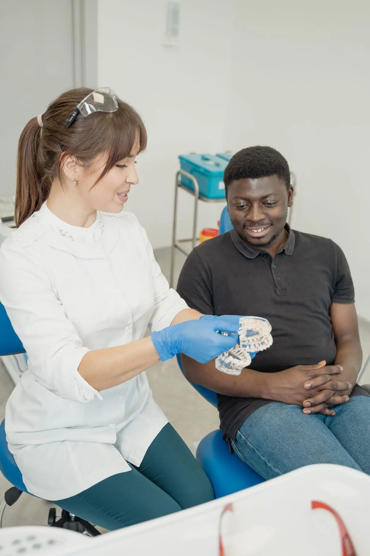 A dentist showing a patient a cast of their own teeth