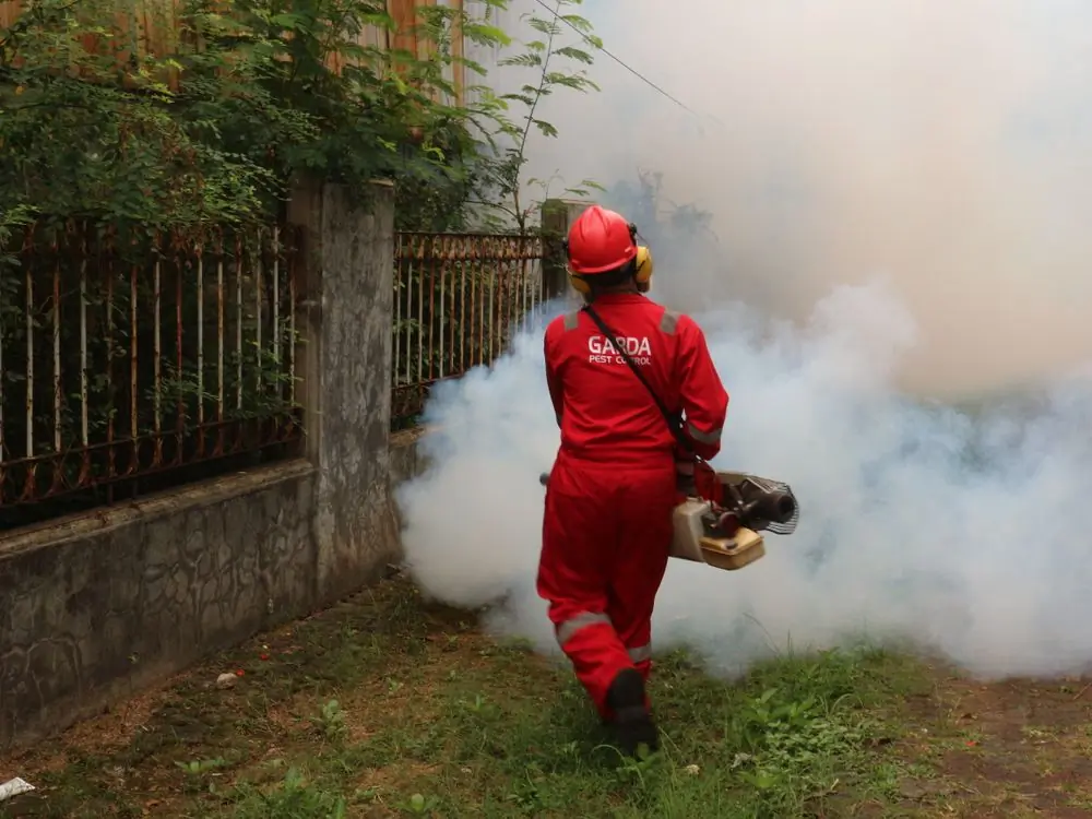 A technician fogging a compound at dusk
