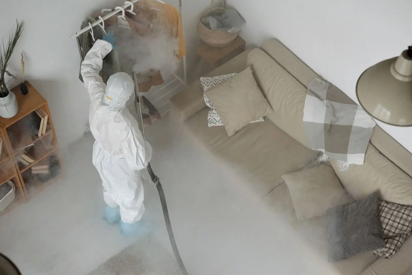A technician sanitising a living room