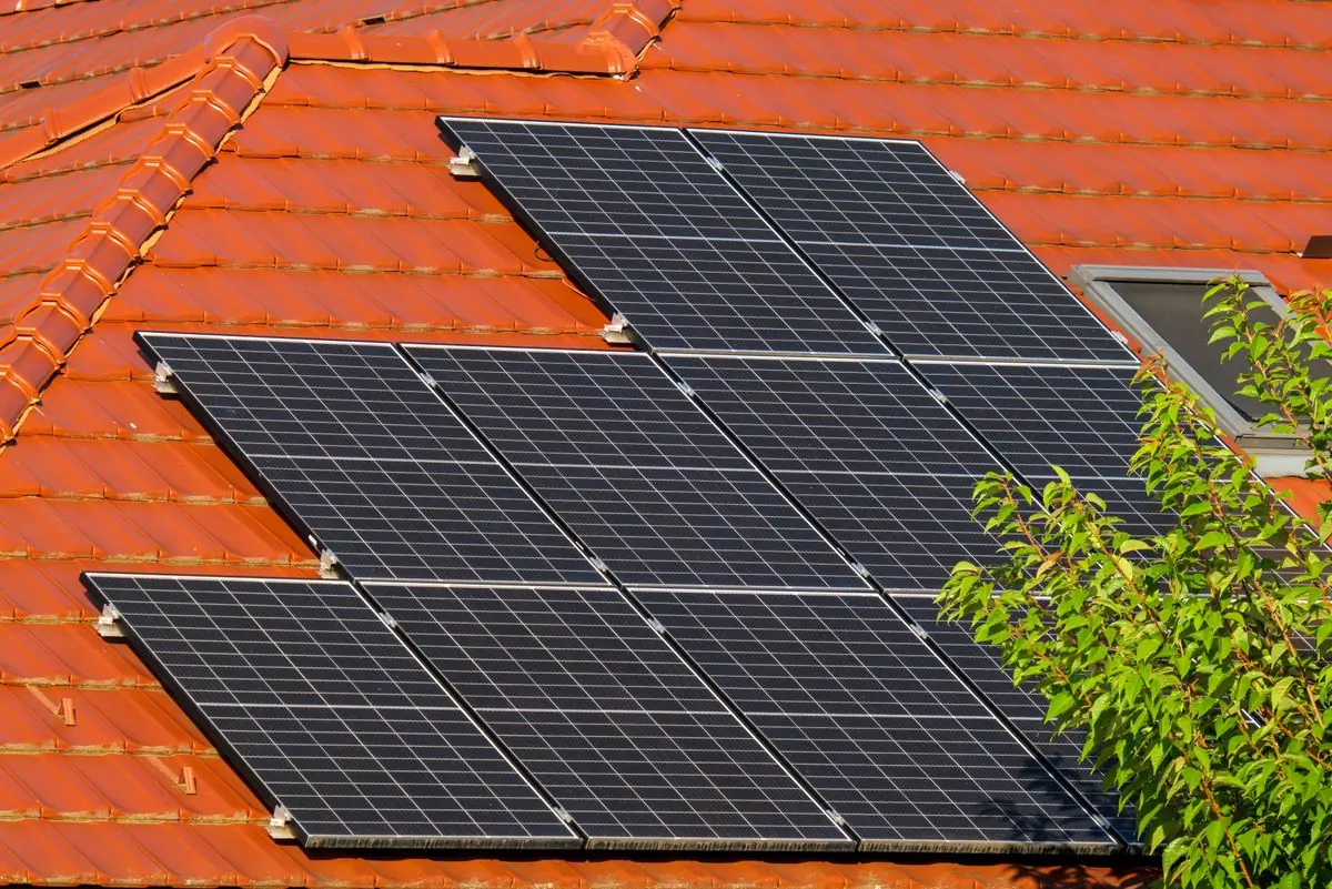 Three solar panels fitted flush to the tiled roof of a house