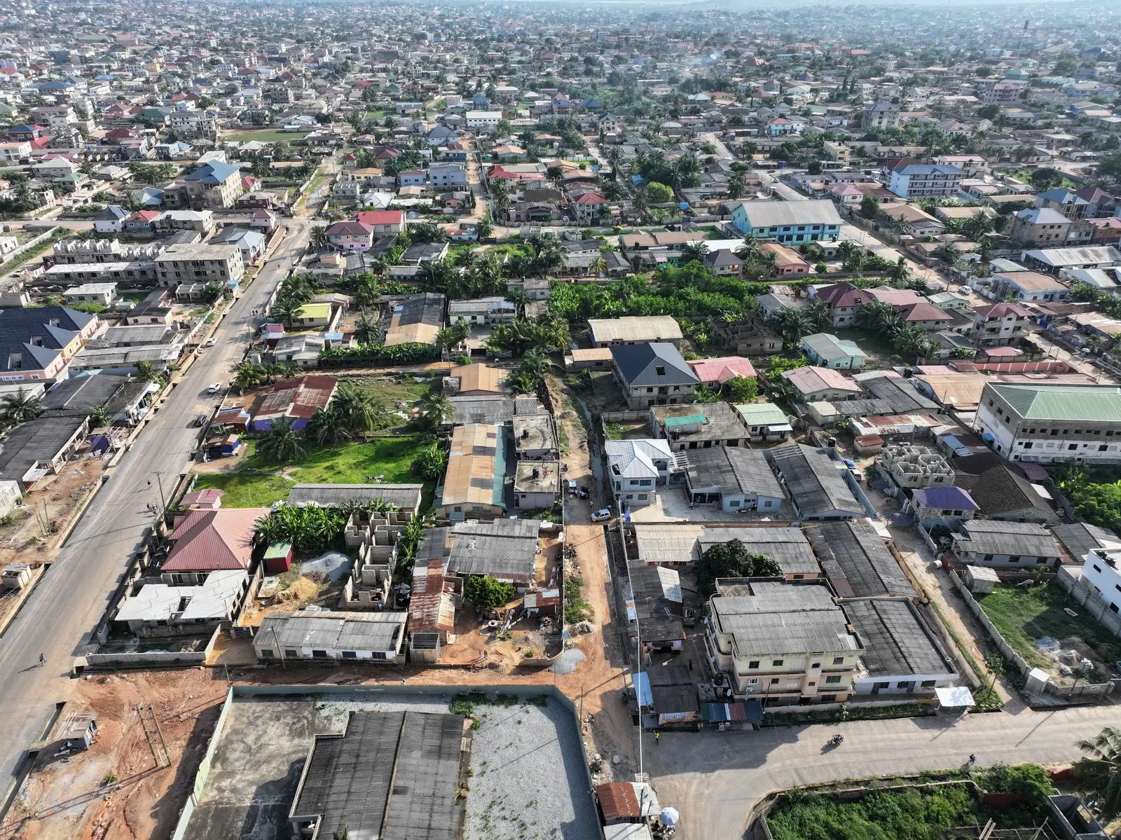 An aerial view of a dense Accra neighbourhood, every house showing its bare roof