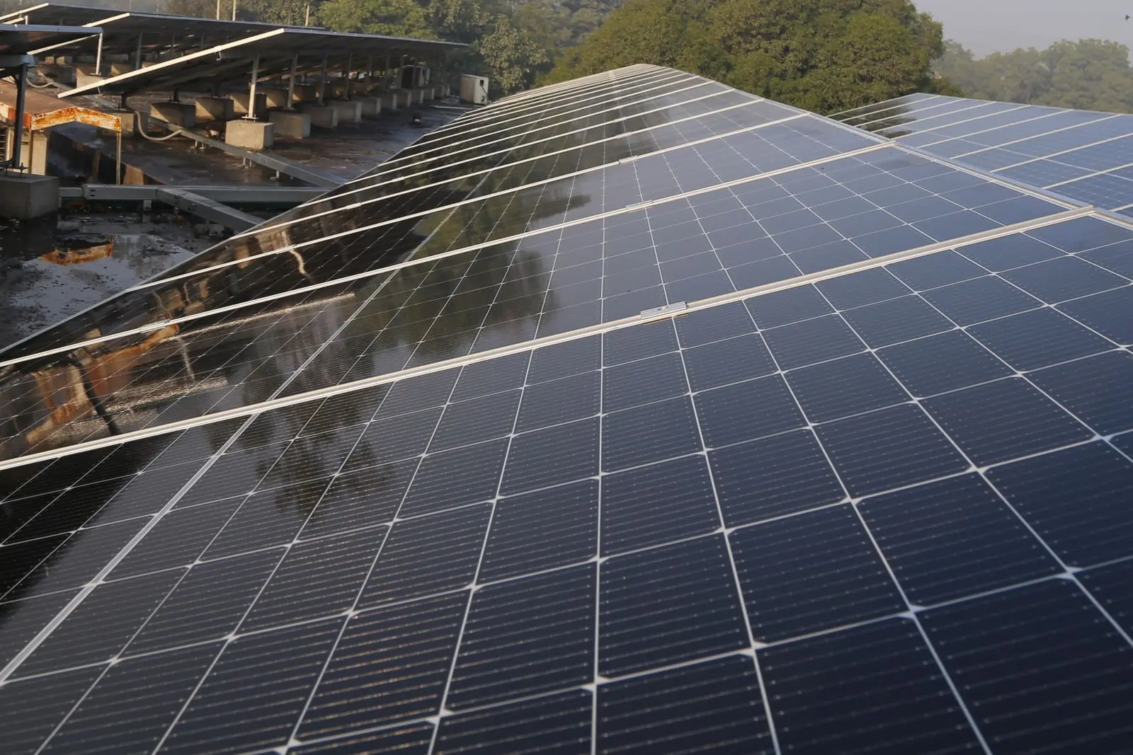 A large rooftop array photographed low along the panels in hazy afternoon light