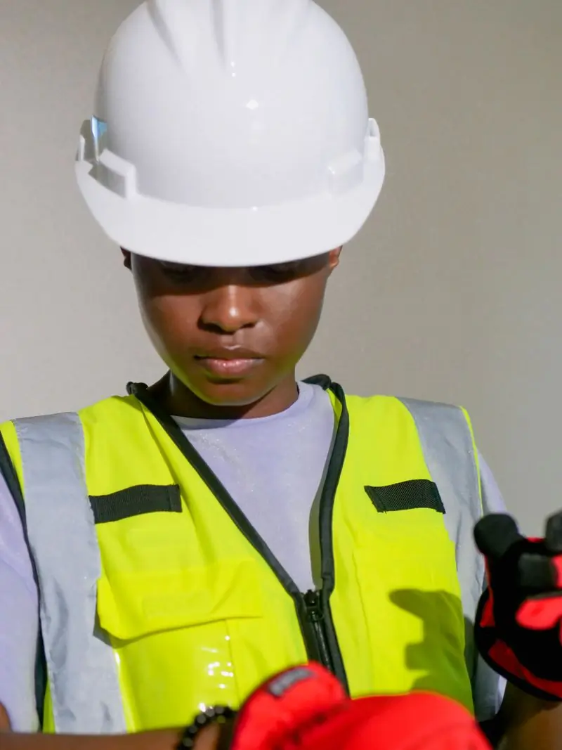 An installer in a white hard hat and reflective vest at work