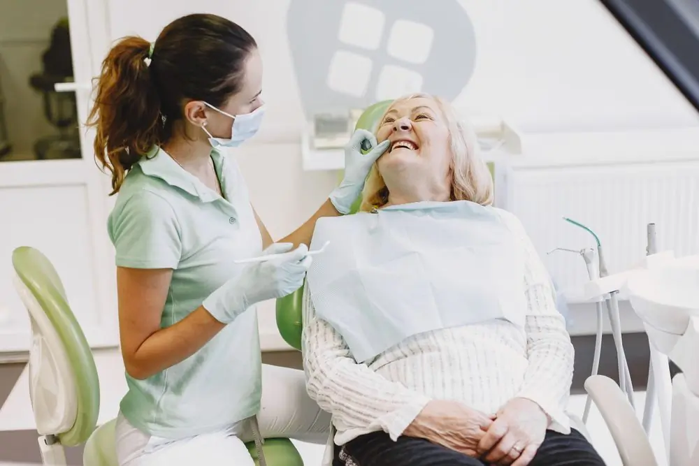 An older patient seeing her new smile in the mirror