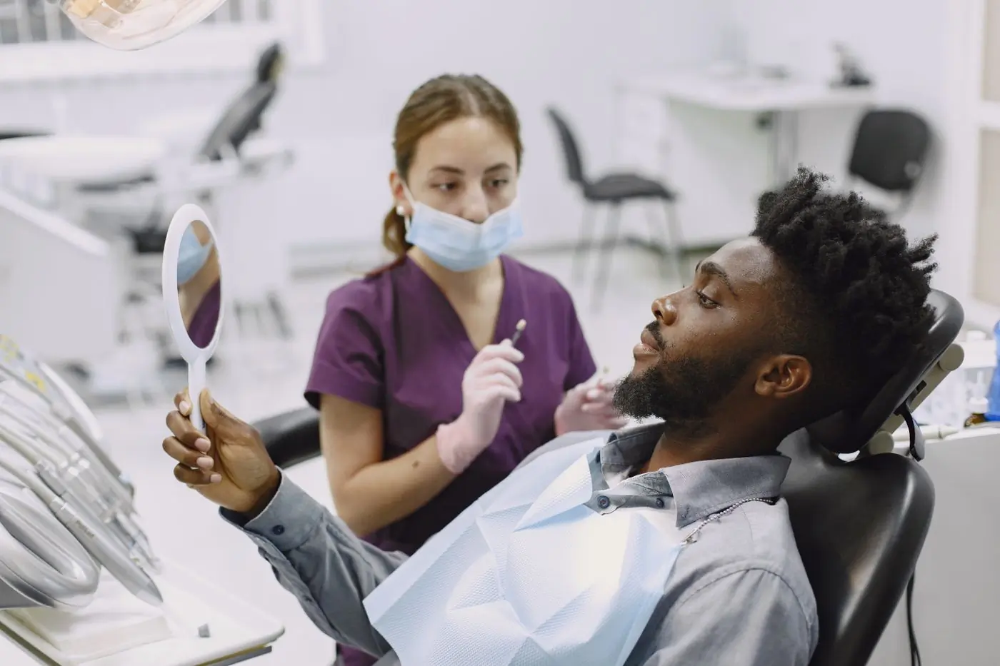 A patient seeing the result of a treatment in the hand mirror