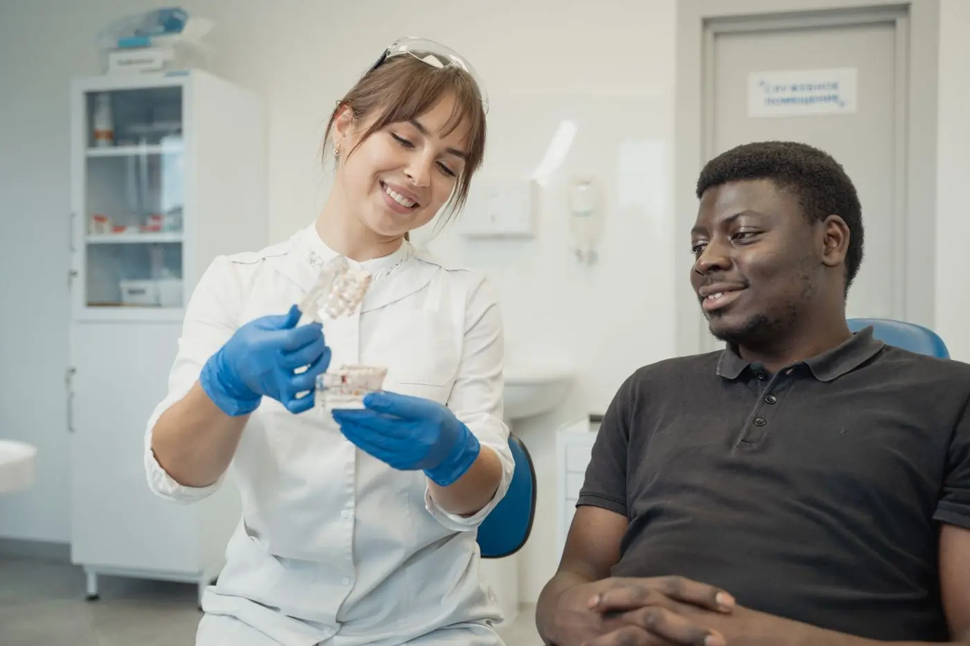 A dentist explaining a treatment to a patient using a cast