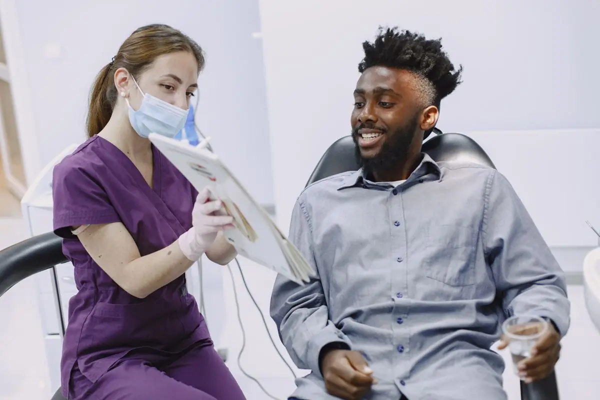 A dentist showing a patient their treatment plan on screen