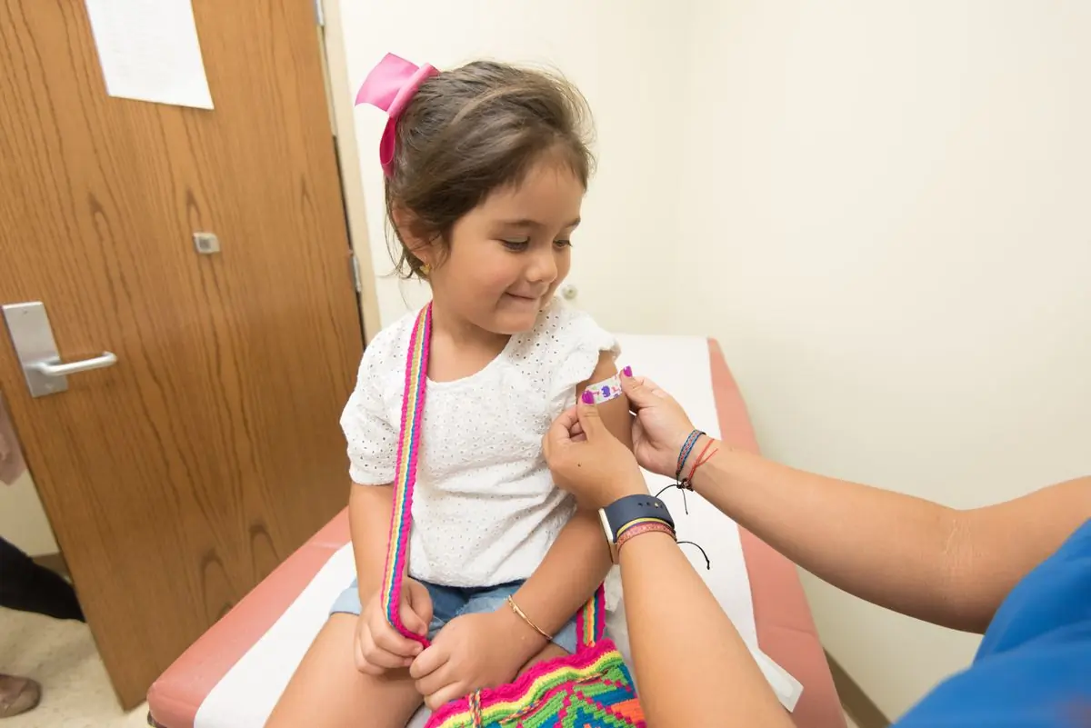 A young girl with a plaster on her arm after a routine vaccination